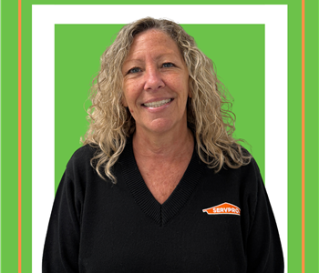 A SERVPRO employee is shown in a white shirt